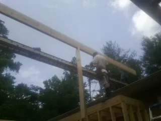 Carpenter setting a ridge beam over a new addition frame — Ice Dam Removal by Roofing Brothers in East Springfield