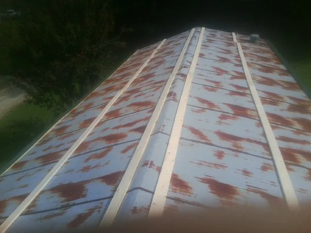 Rusted metal roof panels with new wood purlins before replacement — Storm Damage Roof Repair in East Springfield by Roofing Brothers